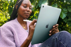 Woman sitting outside using the Apple iPad Air 11-inch with M3.