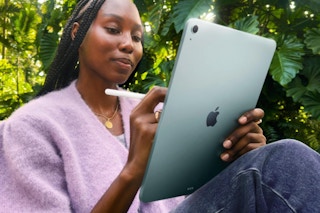 Woman sitting outside using the Apple iPad Air 11-inch with M3.