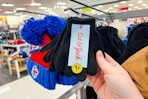 hand grabbing a set of kids' winter gloves off a target shelf