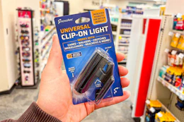 person holding a clip-on led light in a store aisle