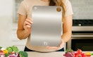 a person holding a titanium cutting board 