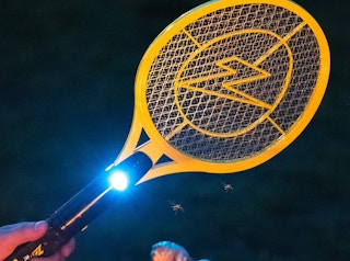 an electric fly swatter in the dark with a light on it