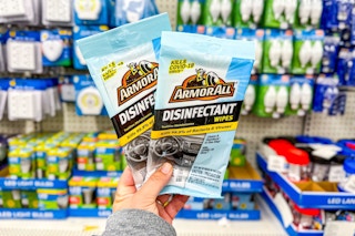 person holding 2 packs of armorall disinfecting wipes