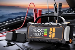 okrinec Battery Jumper Starter Portable sitting on a car battery.