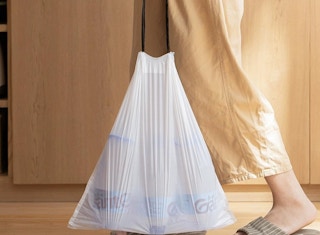 a person holding a trash bag full of trash