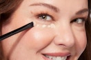 a woman using laura geller concealer