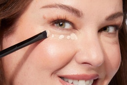 a woman using laura geller concealer