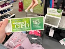 A person holding Kohl's cash near a sales sign