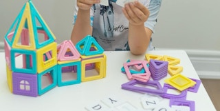 child playing with magnetic building shape tiles