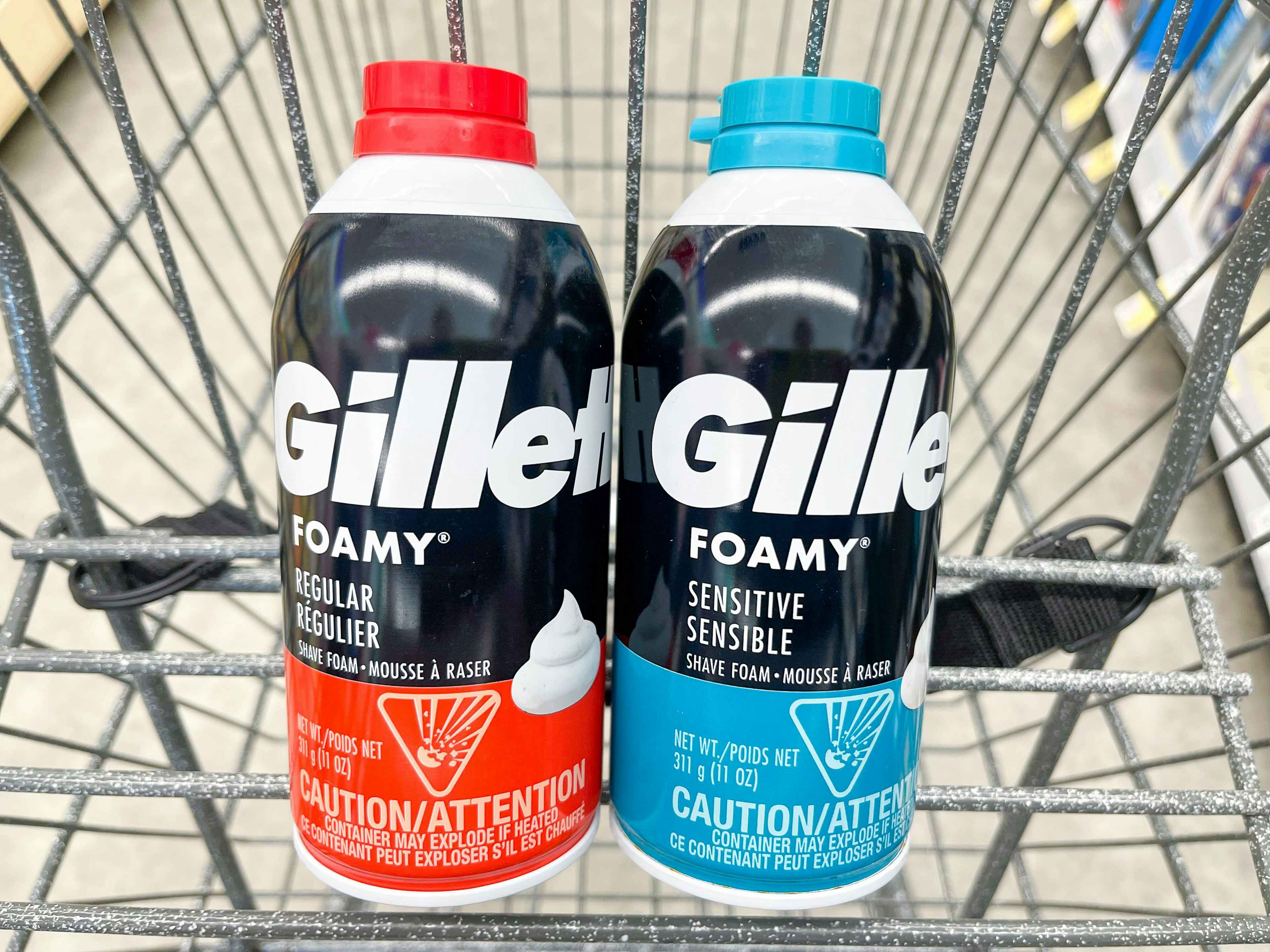 A couple cans of Gillette shaving cream sitting in a store cart.