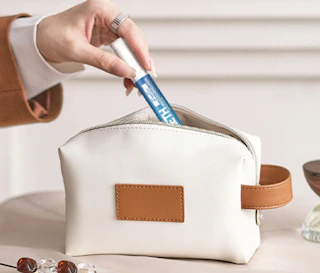 a hand putting a teeth whitening pen in a pouch