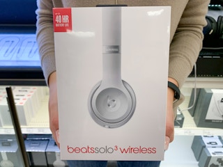 A woman holding Beats headphones