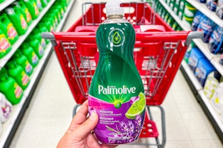 hand holding a bottle of palmolive dish soap in front of a target cart