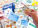 hands holding a mix of expired fast food coupons 