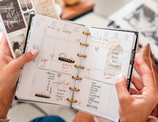 A person holding up a planner