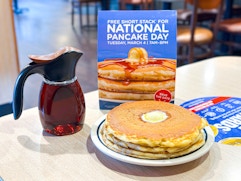 a pancake stack next to an international pancake day sign at ihop