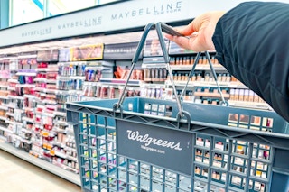 walgreens makeup area and hand holding a shopping basket