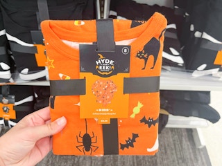 hand holding hyde and eek kids halloween pajamas at target