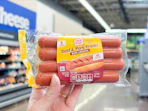 hand holding a pack of oscar mayer hot dogs at Walmart
