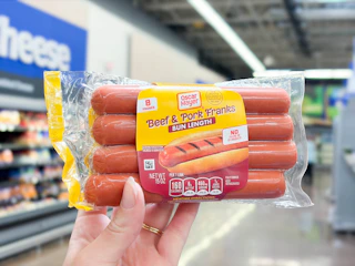 hand holding a pack of oscar mayer hot dogs at Walmart