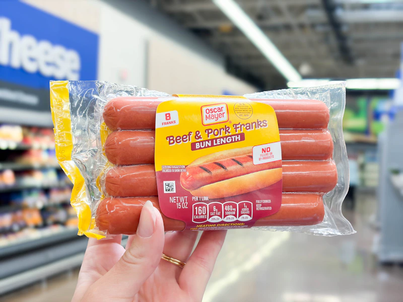 hand holding a pack of oscar mayer hot dogs at Walmart