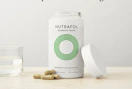vitamins in a bottle and on a table with a cup of water