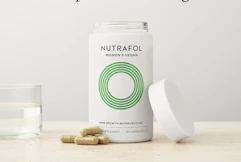 vitamins in a bottle and on a table with a cup of water