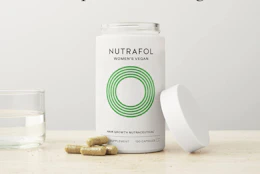 vitamins in a bottle and on a table with a cup of water