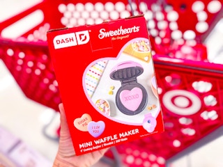 hand holding a dash waffle maker in front of a target shelf