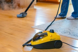 someone using a wagner power steamer on their floors at home