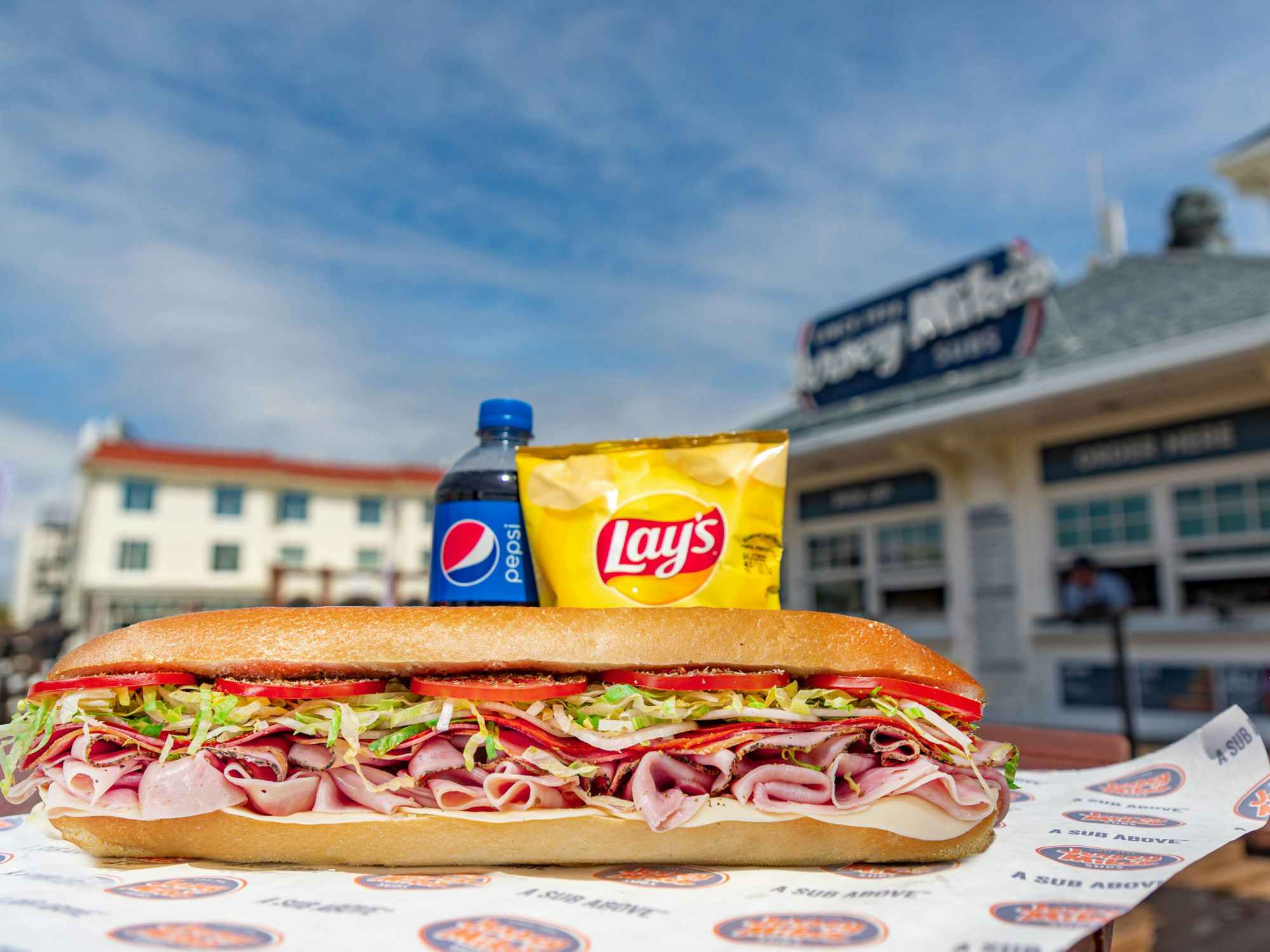 A Jersey Mike's sub, chips, and drink on a table
