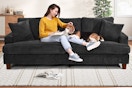 A black 87-inch corduroy sofa with woman and dog sitting on it in a home setting
