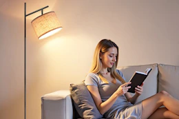 a woman sitting under a lamp