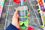 hand holding dove men+care plant powered body wash over a shopping cart