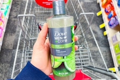 hand holding dove men+care plant powered body wash over a shopping cart