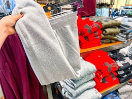 Joggers held up infront of Under Armour shorts in Store