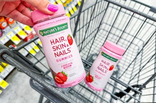 person putting nature's bounty hair, skin, nails vitamins in a cart