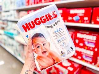 hand holding huggies snug & dry baby diapers pack at target