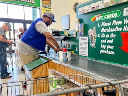 A Menards employee scanning items at the checkout lane.