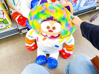hand holding stuffed plush toy in walmart toy aisle