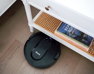 a shark robot vacuum going under an end table