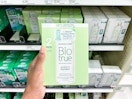 hand holding a pack of biotrue contact solution at target