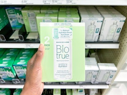hand holding a pack of biotrue contact solution at target