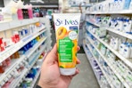 person holding a st ives face scrub in an aisle