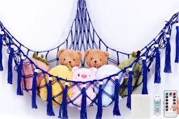 Krislait Stuffed Animal Hammock hanging from a kids' room wall.