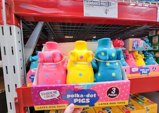 hand holding a 3-pack of polka dot pig dog toys