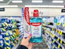 hand holding colgate toothpaste and mouthwash