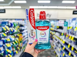hand holding colgate toothpaste and mouthwash