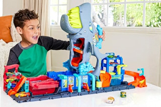 Lifestyle image of the Hot Wheels City Ultra Shark Car Wash playset (little boy playing in home)