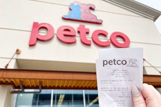 a person holding up at petco receipt outside of petco